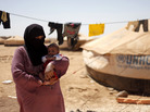 Omm Ahmed, a refugee from Daraa, Syria, carries her infant near her tent at Zaatari Refugee Camp in Mafraq, Jordan, on Sunday. Syrian civilians have borne the greatest brunt of the conflict in their country. Omm Ahmed, a refugee from Daraa, Syria, carries her infant near her tent at Zaatari Refugee Camp in Mafraq, Jordan, on Sunday. Syrian civilians have borne the greatest brunt of the conflict in their country.