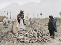 In March, villagers pray over the grave of a victim of a shooting rampage in the Panjwai district of Kandahar province south of Kabul, Afghanistan.