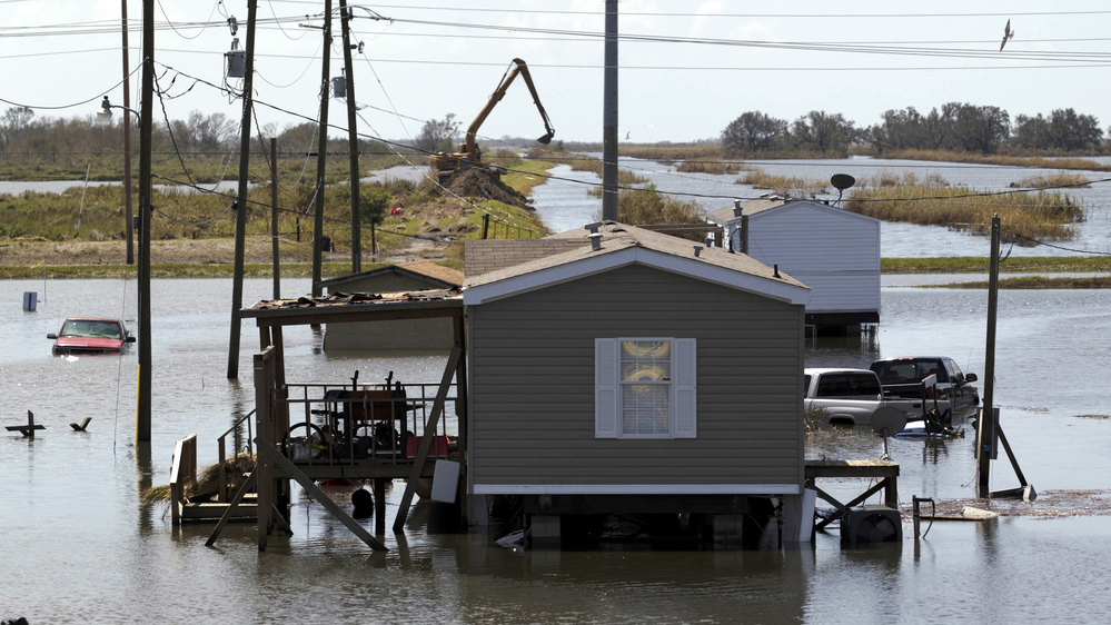 Trucks are flooded in receding flood waters from Hurricane Isaac along Louisiana Hwy 23 near West Point a La Hache, La., in Plaquemines Parish Monday.