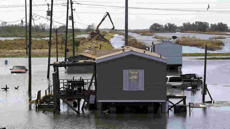 Trucks are flooded in receding flood waters from Hurricane Isaac along Louisiana Hwy 23 near West Point a La Hache, La., in Plaquemines Parish Monday.