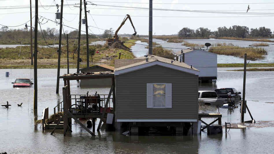 Trucks are flooded in receding flood waters from Hurricane Isaac along Louisiana Hwy 23 near West Point a La Hache, La., in Plaquemines Parish Monday.