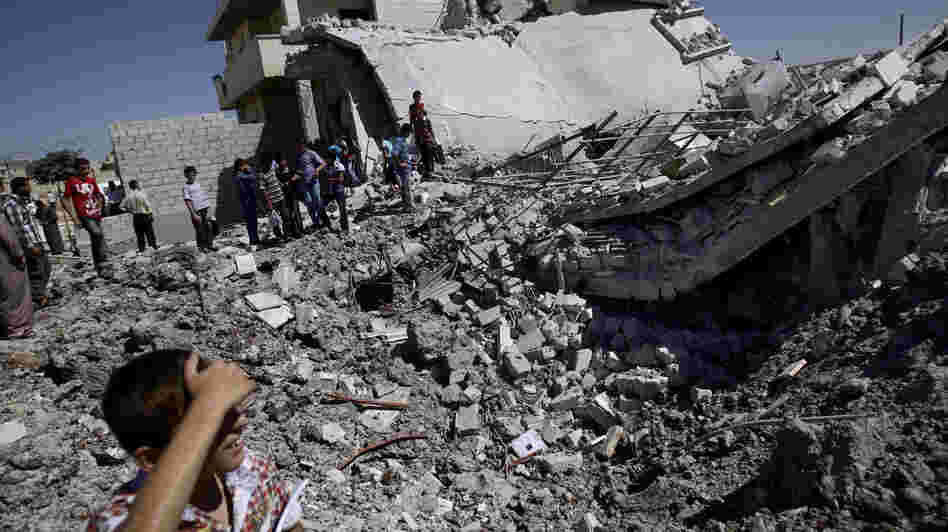 Syrians gather by the rubble of a house destroyed by shelling in the northern town of Azaz, on the outskirts of Aleppo, on Monday. Syrians gather by the rubble of a house destroyed by shelling in the northern town of Azaz, on the outskirts of Aleppo, on Monday.