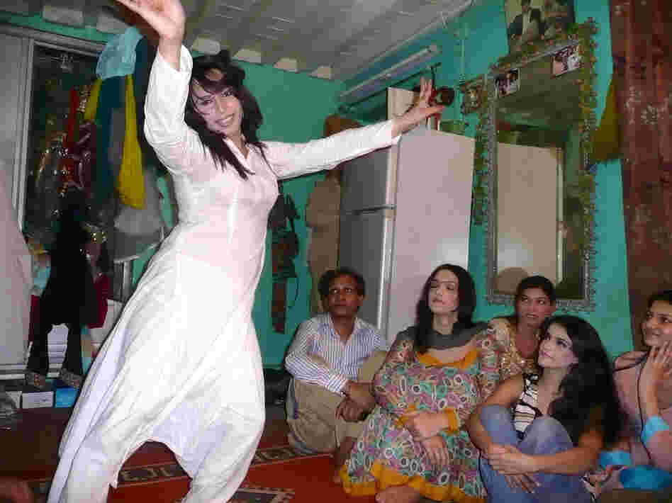 Sameeha, a 22-year-old transgender wedding performer, dances as friends look on during a rehearsal at a friend's home in Rawalpindi.