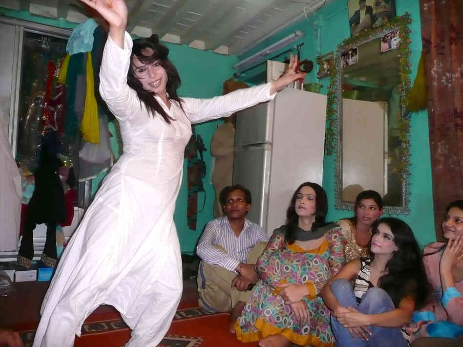 Sameeha, a 22-year-old transgender wedding performer, dances as friends look on during a rehearsal at a friend's home in Rawalpindi.