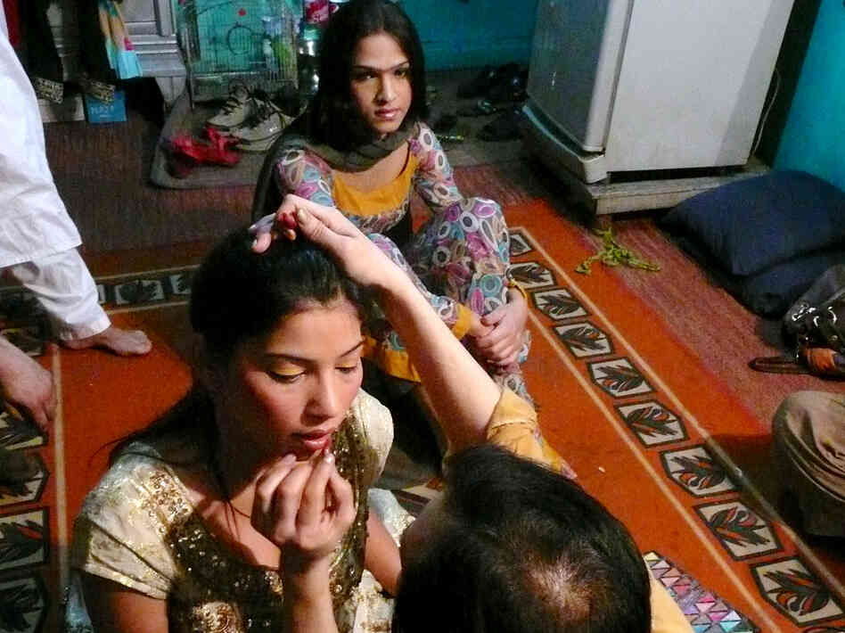 Malaika, 19, sits behind a friend while her makeup is applied at a friend's home in Rawalpindi. The transgender teenager got straight As in school before dropping out because of discrimination from her classmates. Now she dances at weddings and other parties for money.