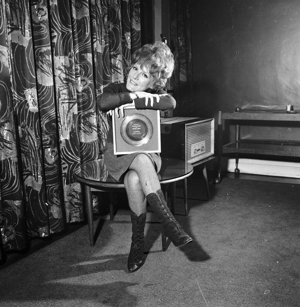 A less complicated time? Petula Clark holds her 1965 gold record for "Downtown," an uptempo song in a major key.