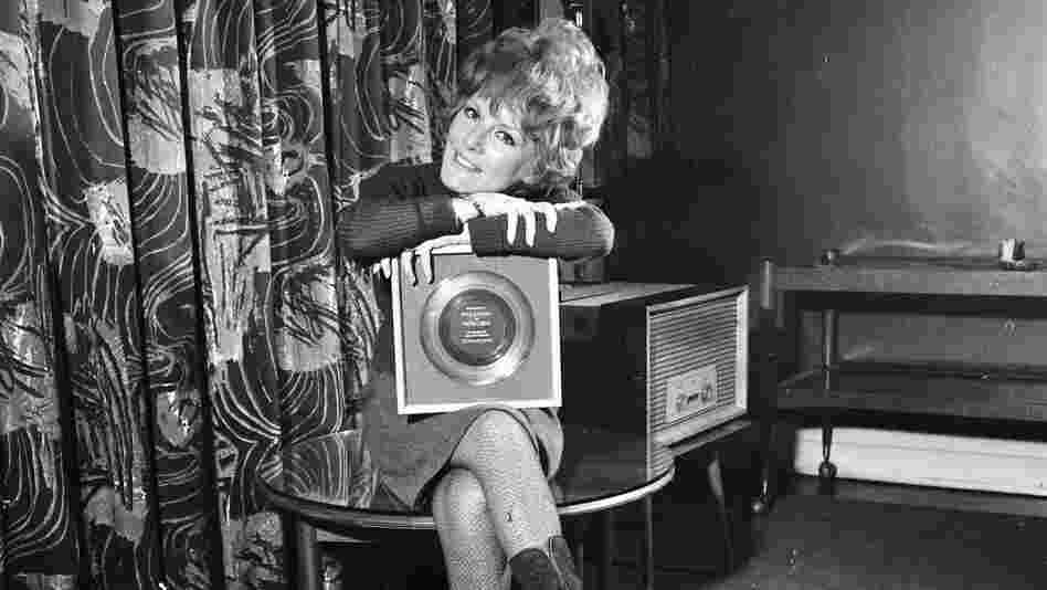 A less complicated time? Petula Clark holds her 1965 gold record for "Downtown," an uptempo song in a major key.