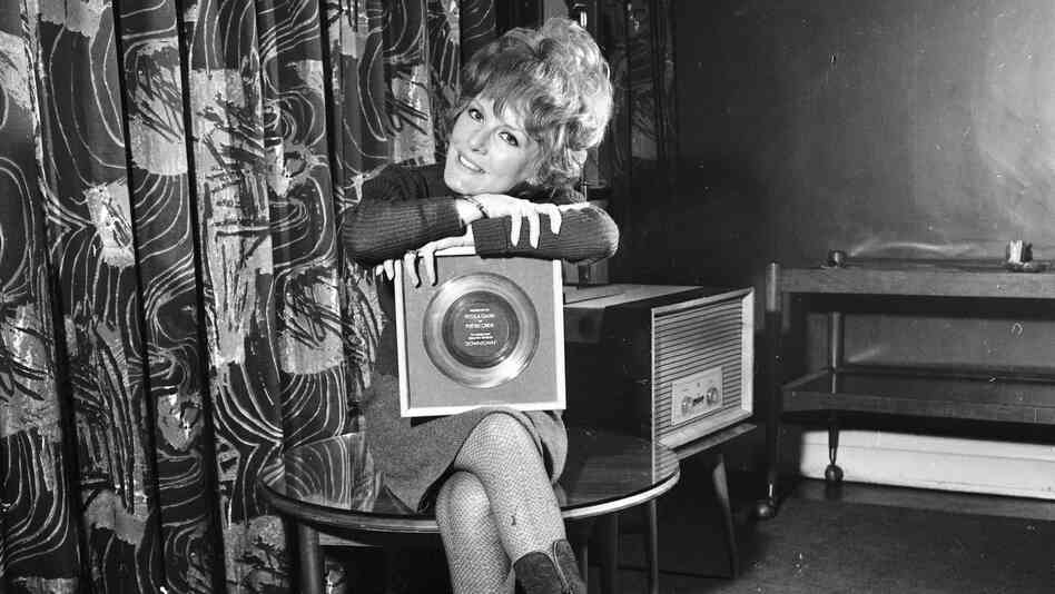 A less complicated time? Petula Clark holds her 1965 gold record for "Downtown," an uptempo song in a major key.