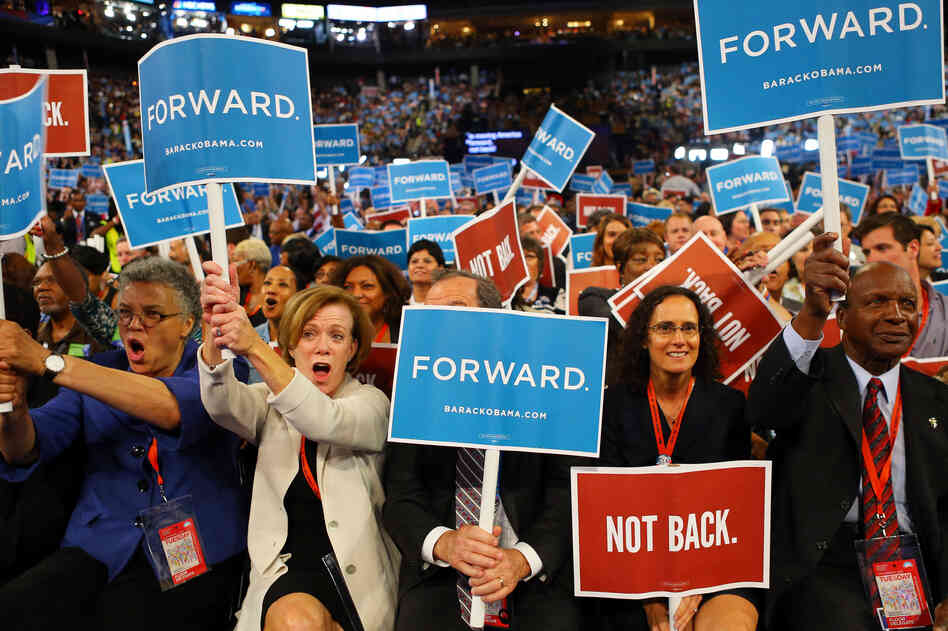 People hold signs that read "Forward" and "Not Back" during day one of the convention.