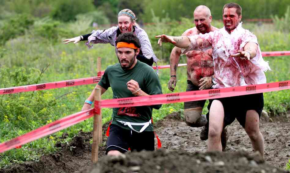 A runner tries to escape with his life as zombies pursue him during the Run for Your Lives race. The 5K course is littered with obstacles — and the undead.
