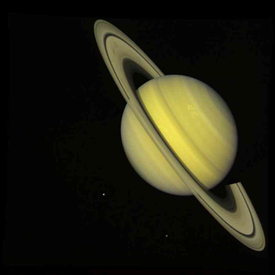 The two Voyager spacecraft launched on Aug. 20, 1977, and Sept. 5, 1977, on a mission to explore Jupiter and Saturn. This true-color image, captured by Voyager 2 on July 21, 1981, shows the moons Dione (small dot at left) and Rhea (lower right) near Saturn.