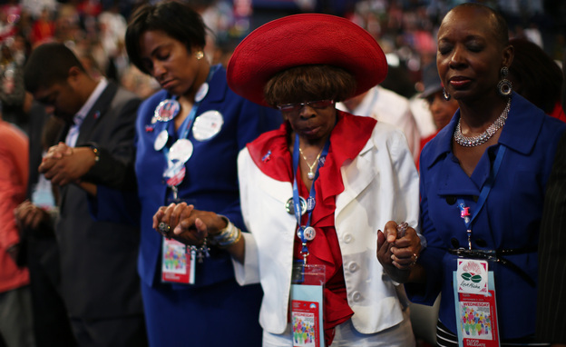 Attendees of the Democratic National Convention in Charlotte, N.C., pray during the invocation. Support for President Obama has remained high for some black voters at the DNC, but enthusiasm for him has waned.