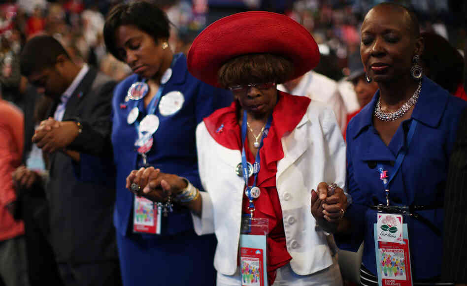 Attendees of the Democratic National Convention in Charlotte, N.C., pray during the invocation. Support for President Obama has remained high for some black voters at the DNC, but enthusiasm for him has waned.