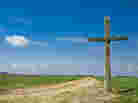 Old wooden cross on a country road.