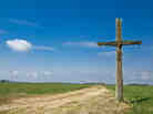 Old wooden cross on a country road.