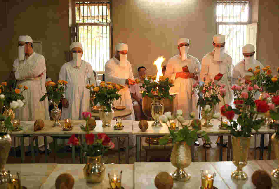 Zoroastrian priests pray to honor the dead inside a temple in Pune, India, on Aug. 18, 2010. Each of the dead is represented by a vase filled with flowers. Parsis forbid images of their funeral ceremonies, where the deceased are taken to the Tower of Silence and consumed by vultures and other birds of prey.
