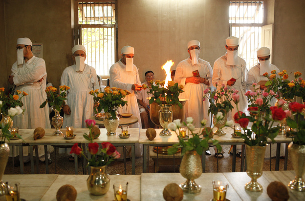 Zoroastrian priests pray to honor the dead inside a temple in Pune, India, on Aug. 18, 2010. Each of the dead is represented by a vase filled with flowers. Parsis forbid images of their funeral ceremonies, where the deceased are taken to the Tower of Silence and consumed by vultures and other birds of prey.