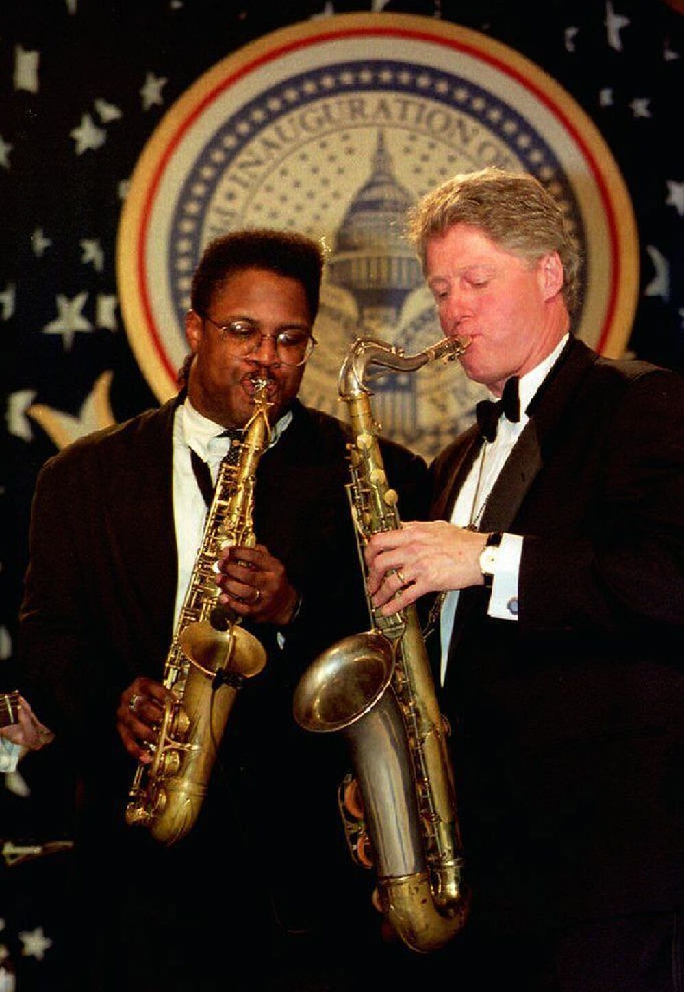 President Bill Clinton plays a saxophone with Everette Harp at the Arkansas inaugural ball on Jan. 20, 1993.
