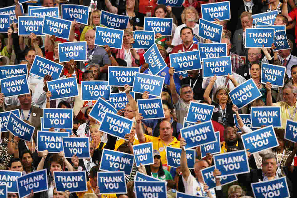 The audience holds signs thanking veterans for their service during retired Navy Adm. John B. Nathman's speech.