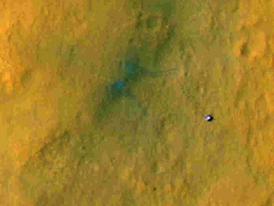 Curiosity from above. It's the small object to the right. The rover's tracks extend up and back to the left.