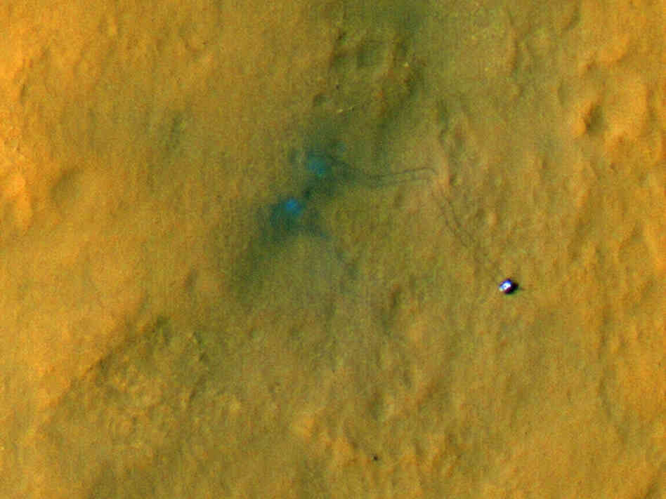 Curiosity from above. It's the small object to the right. The rover's tracks extend up and back to the left.