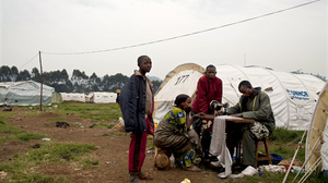 A Congolese man who fled eastern Congo for shelter at a Ugandan refugee camp lugged his sewing machine with him. U.N. officials say tens of thousands have fled for Uganda and Rwanda in recent months.