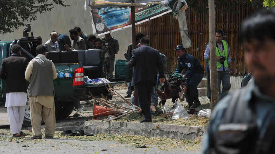 Afghan police carry the remains of a suicide attack victim in the Kabul's diplomatic quarters, home to many Western embassies, on Saturday.