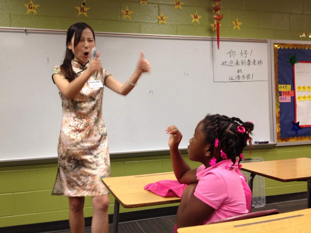 Instructor Huiling Li encourages second-grader Trinity Faulkner on the first day of Mandarin Chinese classes at Brookdale Elementary School in Macon, Ga.