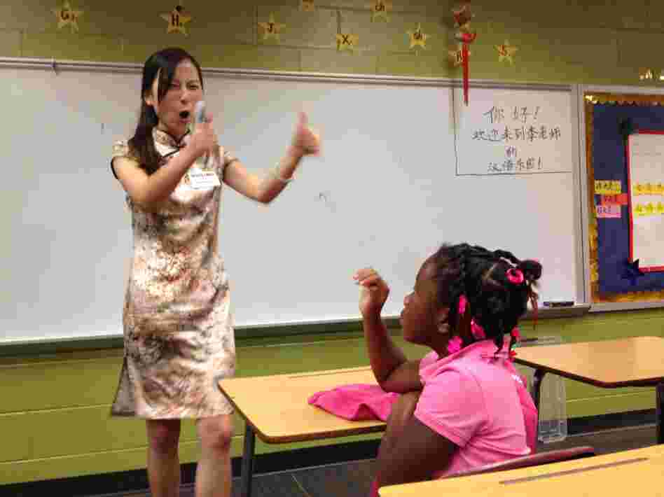 Instructor Huiling Li encourages second-grader Trinity Faulkner on the first day of Mandarin Chinese classes at Brookdale Elementary School in Macon, Ga.