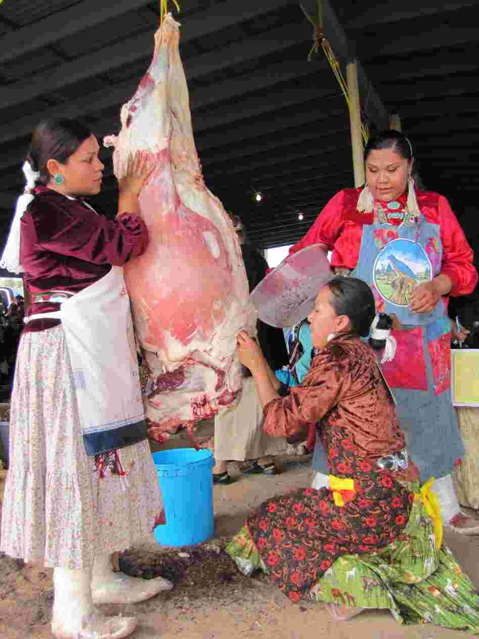 Miss Navajo contestants must work in teams to butcher sheep. From left, Wallitta Begay, Leandra "Abby" Thomas and Charlene Goodluck had to cut the sheep's throat, remove the stomach and quarter the carcass.
