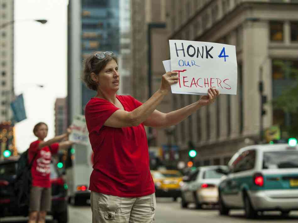 Members of community group Parents 4 Teachers display pro-teacher posters outside City Hall Friday in Chicago. The Chicago Teachers Union has threatened to strike Monday if negotiations fail.