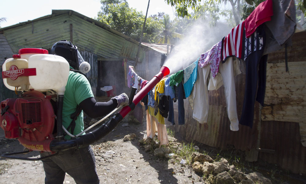 A health worker in the Domincan Republic sprays insecticide between houses to stop dengue fever outbreaks this month.