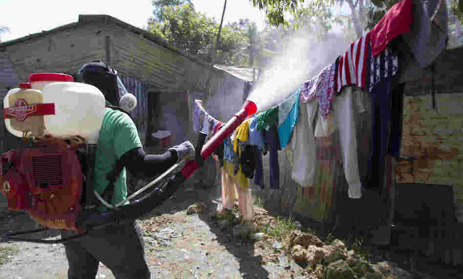 A health worker in the Domincan Republic sprays insecticide between houses to stop dengue fever outbreaks this month.