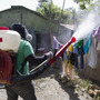 A health worker in the Domincan Republic sprays insecticide between houses to stop dengue fever outbreaks this month.