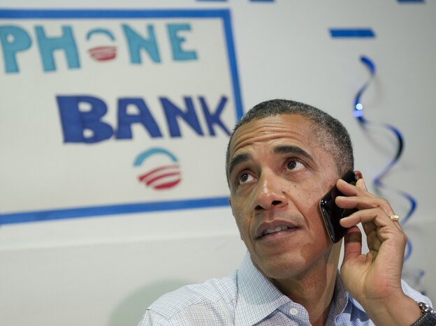 President Barack Obama makes a phone call to a supporter during a visit to the Obama for American campaign field office in Port St. Lucie, Florida, on September 9, 2012, during the second day of a 2-day bus tour across Florida.
