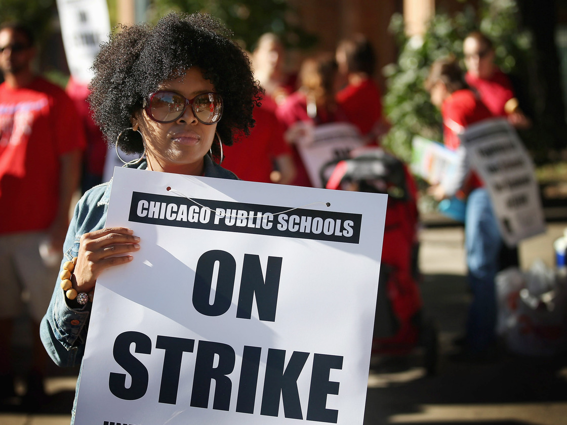Chicago public school teachers picket outside William H.Wells Community High School on Monday.