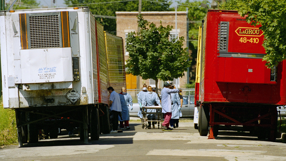 Cook County morgue workers walk between a row of refrigerated trucks outside the morgue in July 1995, when a deadly heat wave struck Chicago.