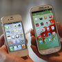 An employee holds Apple's iPhone 4S (left) and Samsung's Galaxy S III at an electronics store in Seoul, South Korea. Some U.S. phone designers are now conflicted over what a recent decision that Samsung infringed on Apple mobile phone patents will mean for their work.