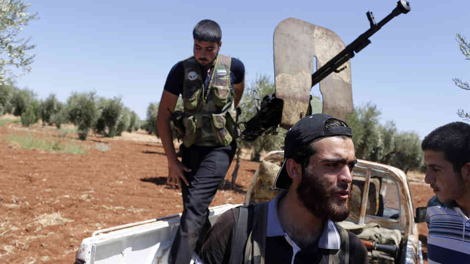 Rebel fighters take up position near the military airport outside the rebel-held town of Azaz in northern Syria on Aug. 21. In rebel-held towns like Azaz, activists are taking on new, risky roles as the uprising against Syrian President Bashar Assad continues.