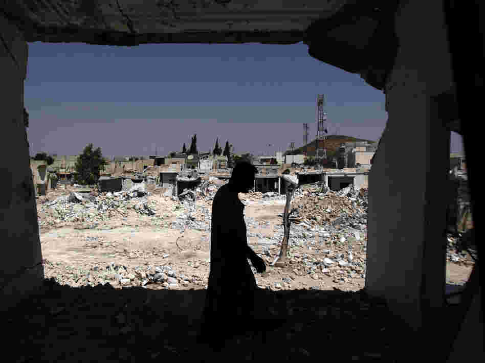 A man walks in his house, which was destroyed in shelling by Syrian government forces, in Azaz, northern Syria. Rebels say the town is under nightly attack.