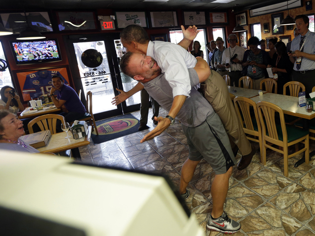 President Obama is lifted off the ground by Scott Van Duzer, owner of Big Apple Pizza and Pasta Italian Restaurant, during an unannounced stop Sunday in Fort Pierce, Fla.
