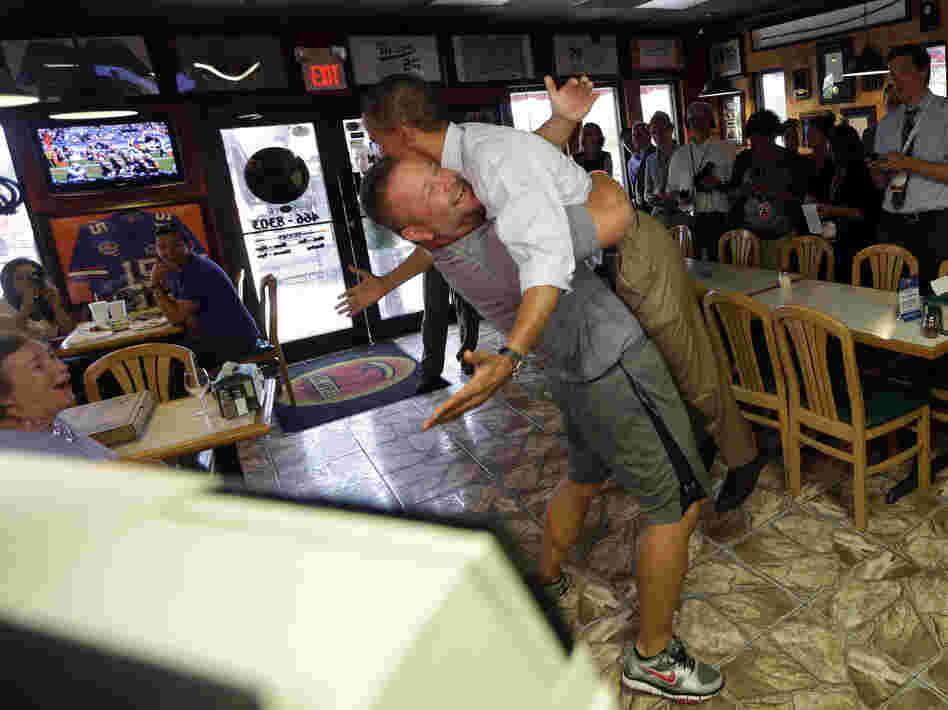President Obama is lifted off the ground by Scott Van Duzer, owner of Big Apple Pizza and Pasta Italian Restaurant, during an unannounced stop Sunday in Fort Pierce, Fla.