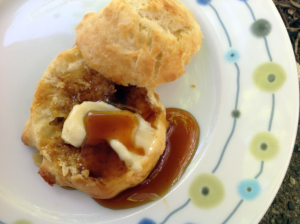 Sorghum syrup poured over a buttered biscuit