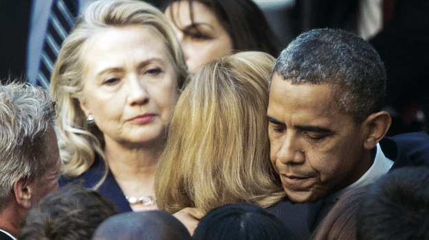 Secretary of State Hillary Clinton looks on as President Obama hugs a State Department employee Wednesday. Obama met with State Department workers after the killing of four Americans in Libya.