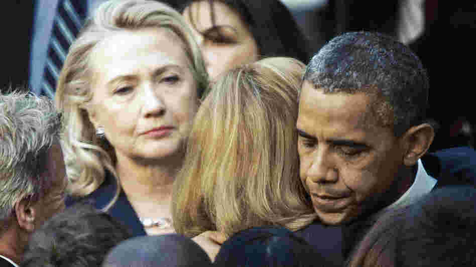 Secretary of State Hillary Clinton looks on as President Obama hugs a State Department employee Wednesday. Obama met with State Department workers after the killing of four Americans in Libya.