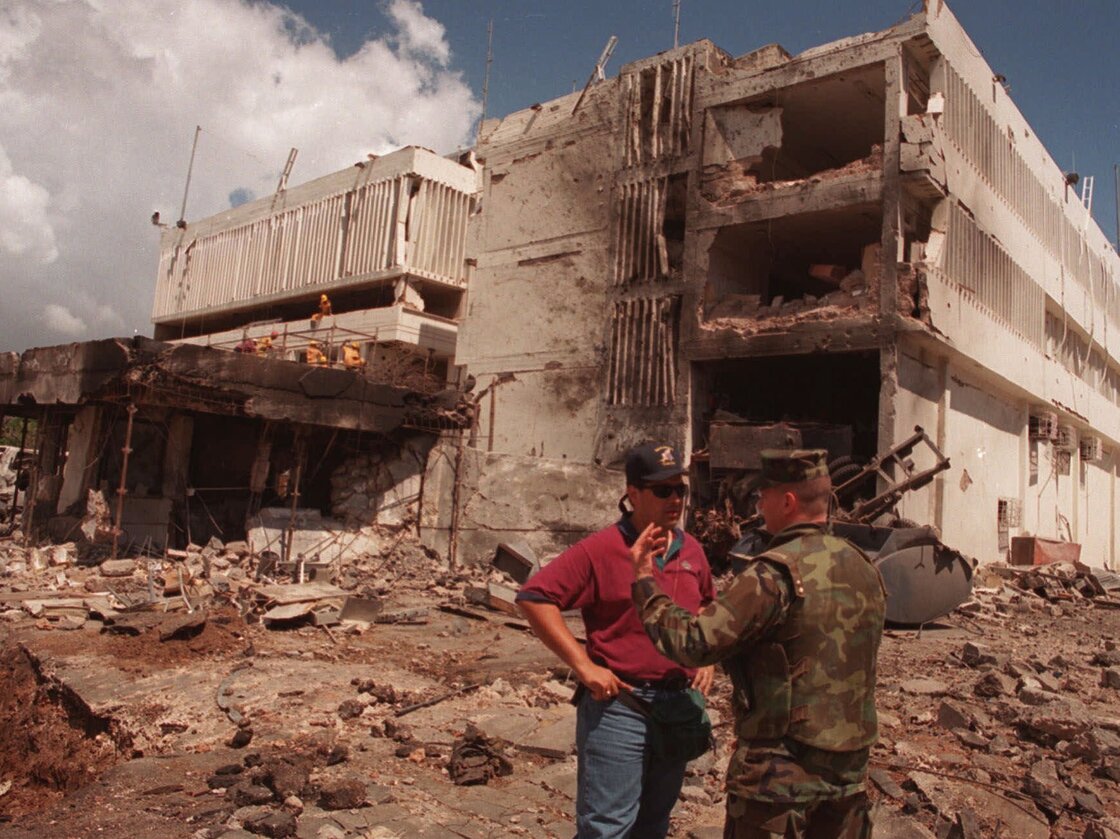 A U.S. Marine talks with an FBI investigator in front of the U.S. Embassy in the Tanzanian capital of Dar es Salaam after it was blown apart in a 1998 terrorist bombing.
