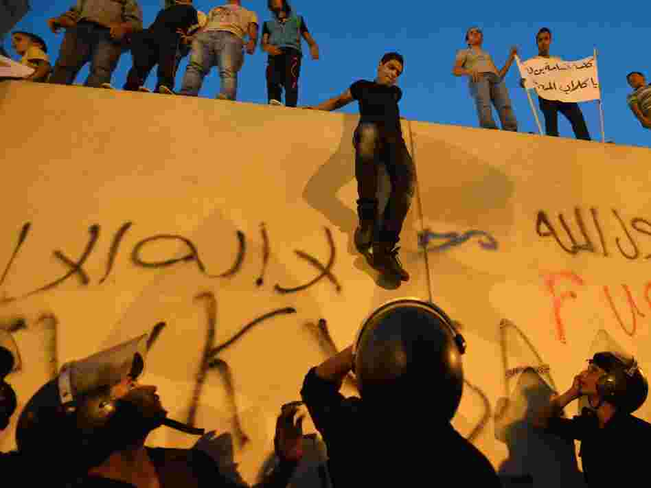 Egyptian riot police stood guard Tuesday as protesters climbed down from the wall of the U.S. Embassy in Cairo during a protest over a film deemed offensive to Islam. Egyptian riot police stood guard Tuesday as protesters climbed down from the wall of the U.S. Embassy in Cairo during a protest over a film deemed offensive to Islam.