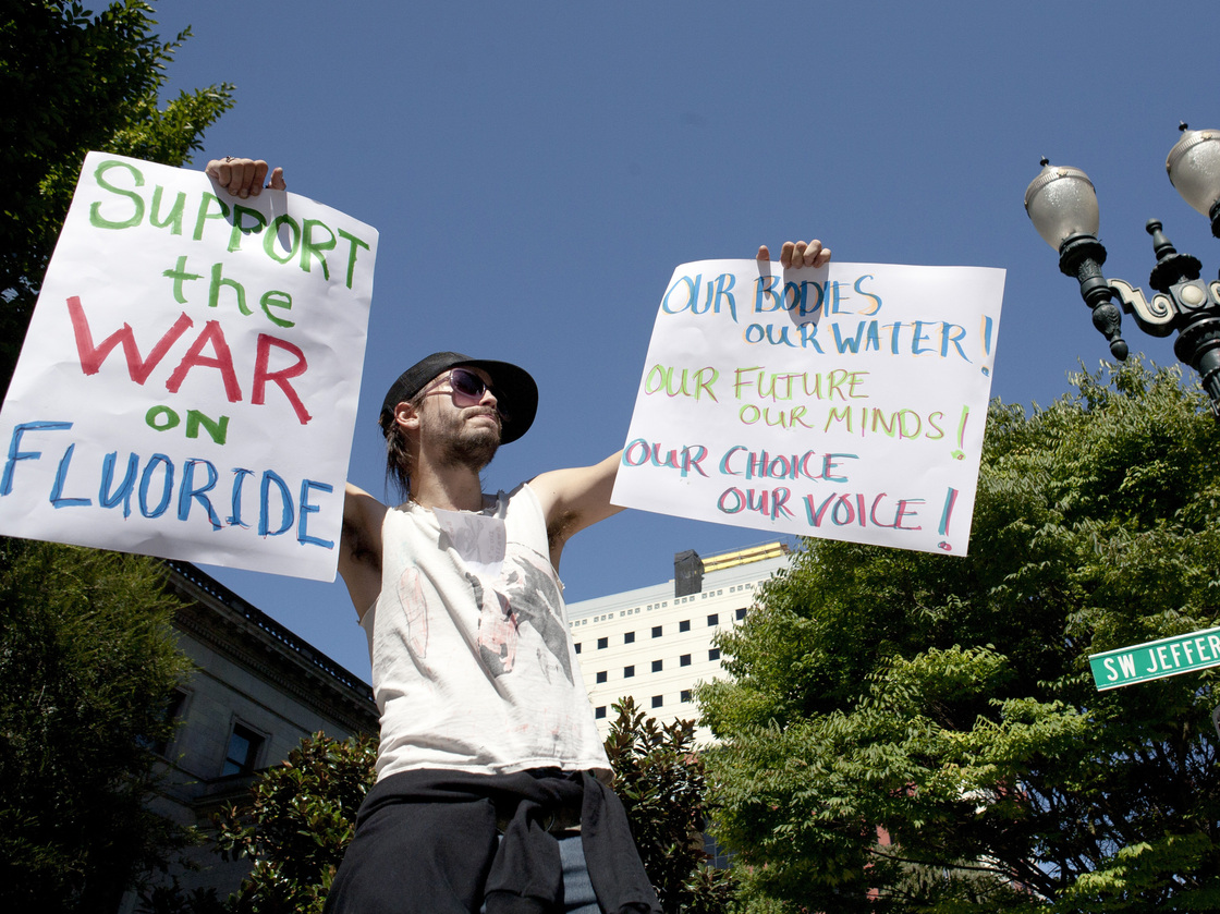 Demonstrator China Starshine holds up signs outside of City Hall in Portland last week.
