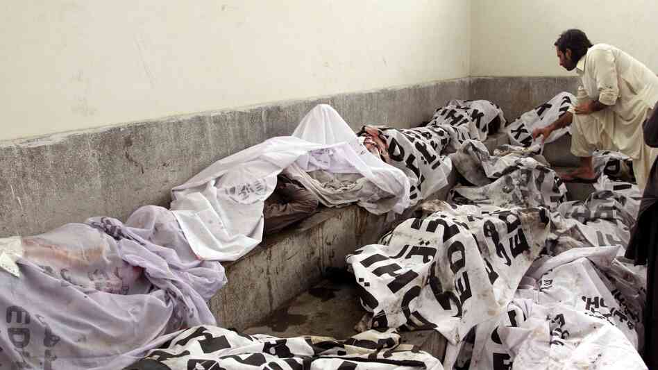 A man tries to identify body of his relative at a mortuary following a huge fire at a garments factory in Karachi, Pakistan.