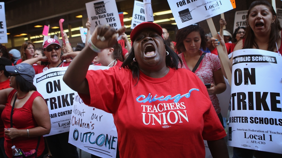 Chicago public school teachers and their supporters picket in front of the Chicago Public Schools headquarters.